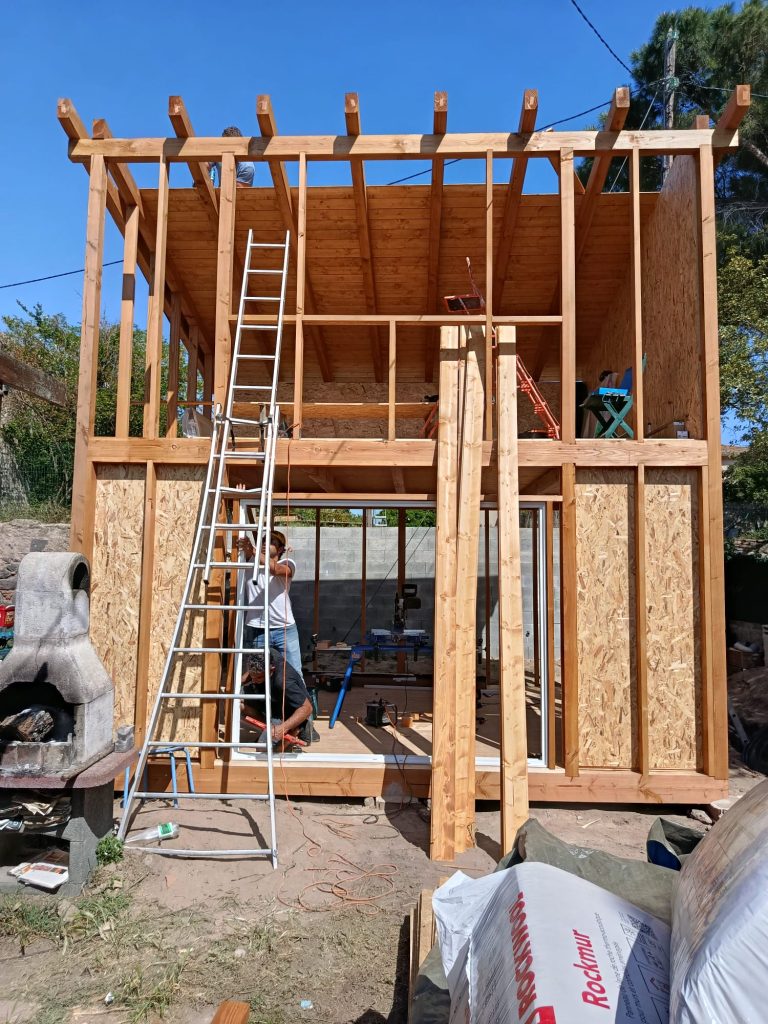 Chantier de chalet en kit avec structure complète et travaux intérieurs en cours